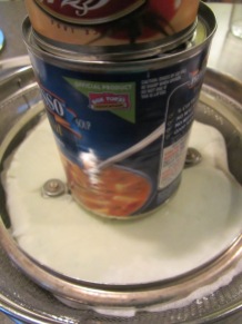Seasoned yogurt, weighed down with a pan lid and cans.