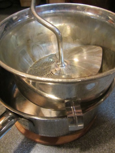 Food mill placed over saucepan.