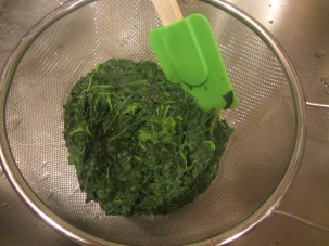 Heated spinach, being drained of excess water.