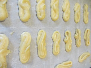 Dough, piped into 'S' shapes for eclairs.