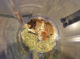 Star anise, cayenne pepper, garlic powder, cumin seed, coriander, onion powder, and fennel seed placed in blender.