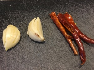 Two cloves of crushed garlic and three red chilies with their stems/seeds removed.