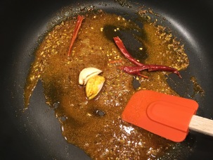 Garlic and chilies added to the skillet.