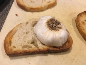 Rubbing toast with garlic.