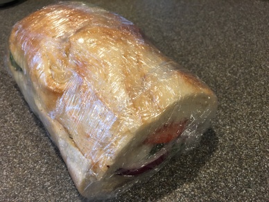 Top layer of bread put on and sandwich wrapped tightly in plastic for two hours.