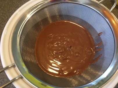 Straining the pudding into a serving bowl.