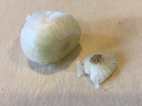 Root end removed from pearl onion.
