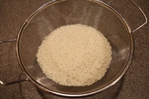Two cups of rice, ready to be rinsed.