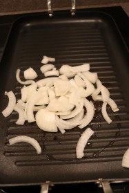 Onion added to oiled grill.
