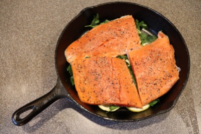 Salmon placed on top of lemon/parsley.