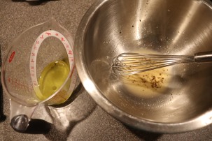 Strained poaching oil to be whisked into vinegar mixture.